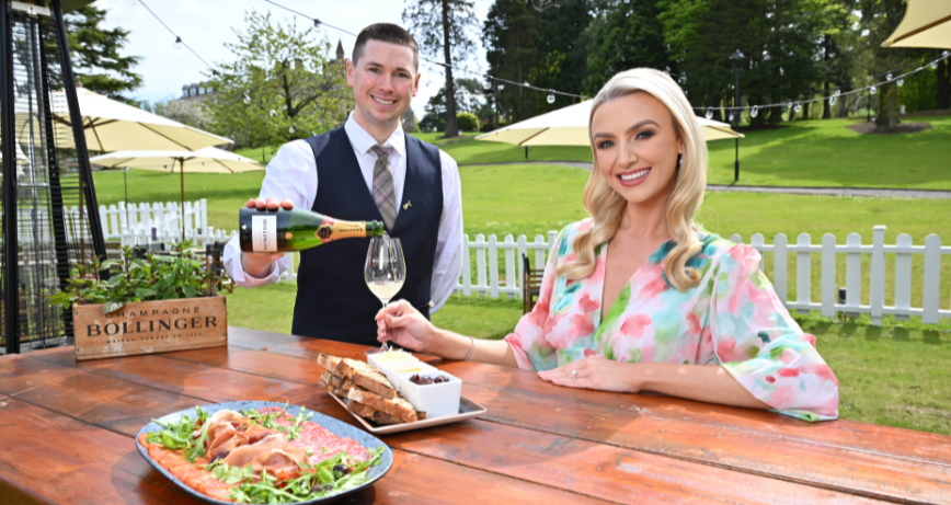 A woman being served champagne in the Bollinger terrace at the Culloden Estate and Spa in Cultra